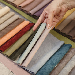 Hand holding fabric swatches against a grid of color samples