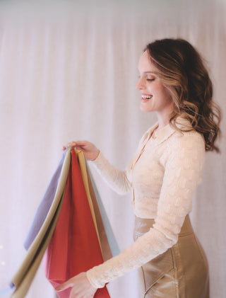 Personal stylist Mylène Amelie holding colour analysis fabric swatches used to identify a client’s most flattering colour palette during a styling consultation in Calgary and virtual sessions worldwide.