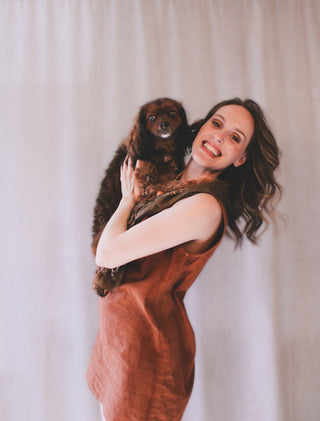 Personal stylist Mylène Amelie holding her dog Chester during a lifestyle portrait used on her styling website, representing her personal brand and approach to wardrobe styling and colour analysis in Calgary and online.