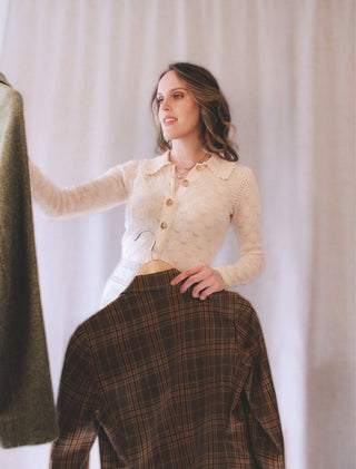Personal stylist Mylène Amelie selecting clothing pieces on hangers during a styling consultation, demonstrating colour analysis and outfit selection techniques for clients in Calgary and virtual styling worldwide.